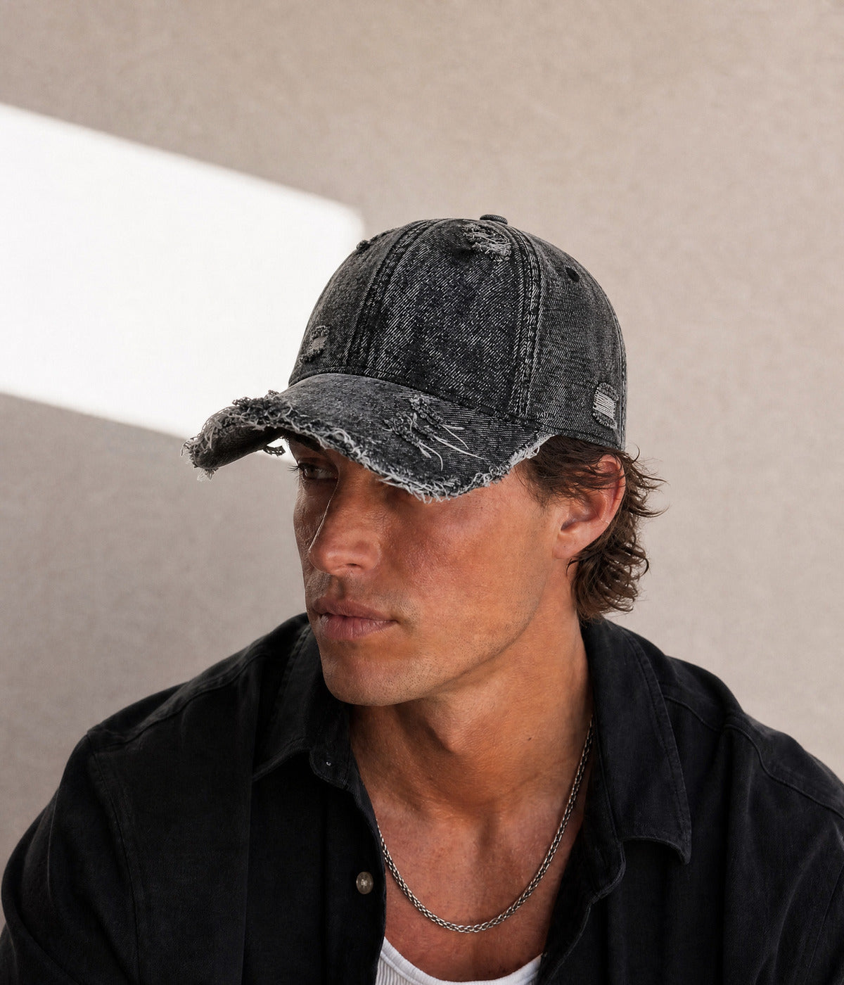 SHREDDED DENIM. BLACK worn by a man