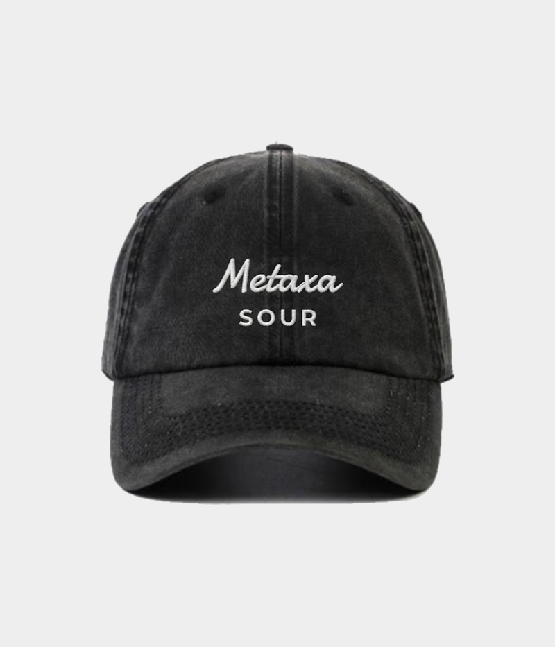 Black cap with 'MCAPS Apparel Metaxa Sour Washed Black Cap Front Viewetaxa Sour' text on a light gray background