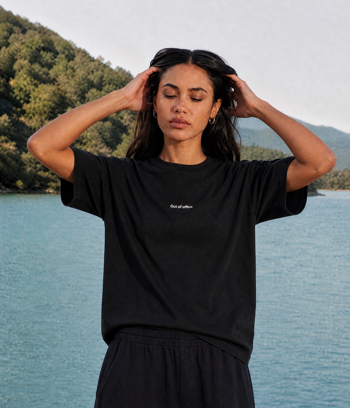 OUT OF OFFICE TEE. BLACK worn by a woman