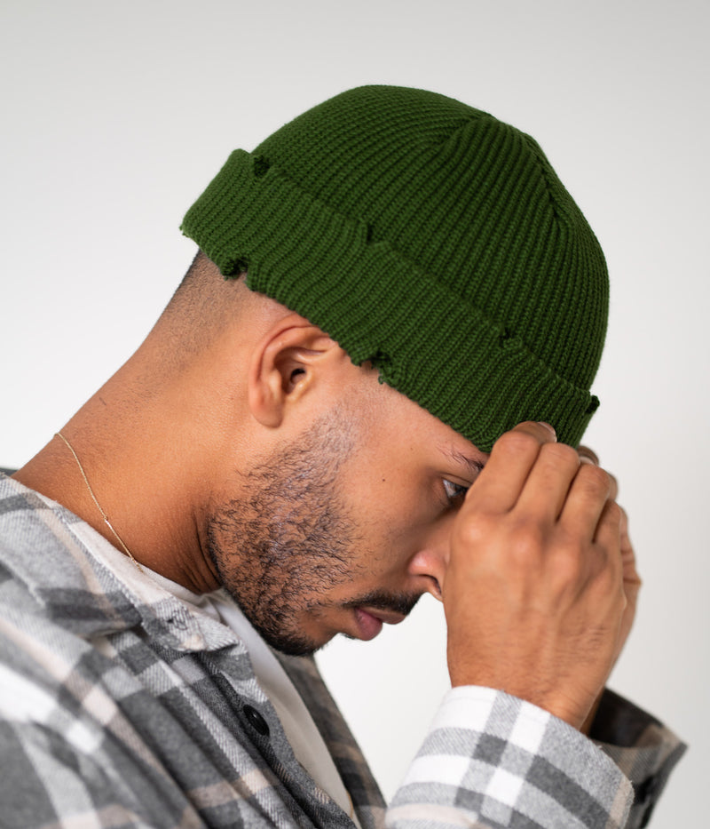 RIPPED FISHERMAN BEANIE. — DARK GREEN worn