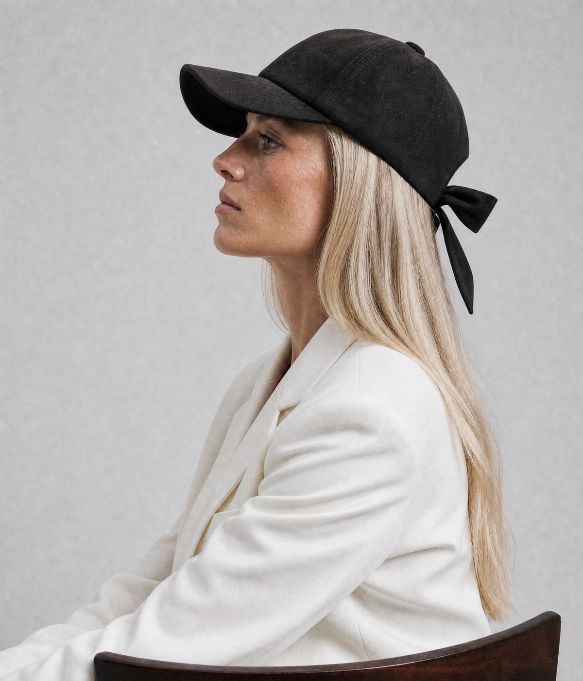 SUEDE BOW CAP. — BLACK worn, side view