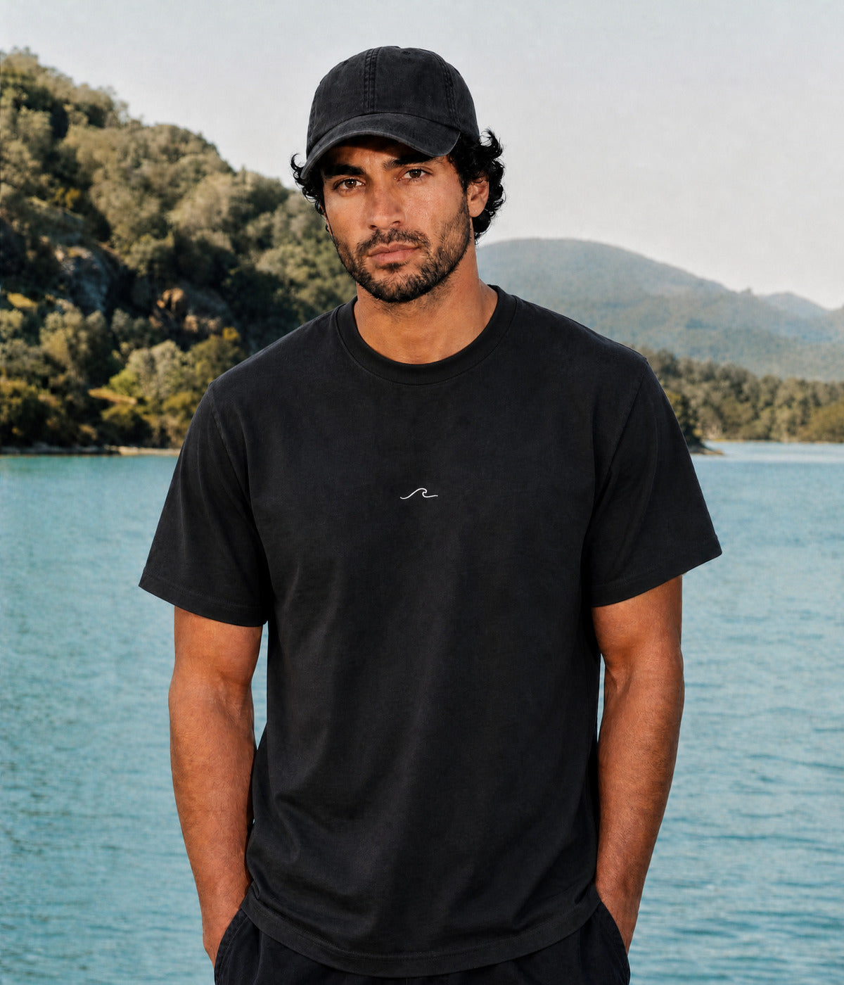THE WAVE TEE. BLACK worn by a man